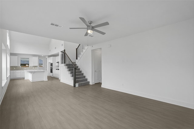 unfurnished living room with dark wood-type flooring and ceiling fan