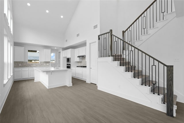 kitchen with white cabinetry, a kitchen island, a breakfast bar, and dark hardwood / wood-style flooring