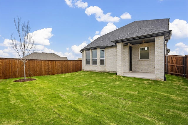 back of property with a yard and a patio