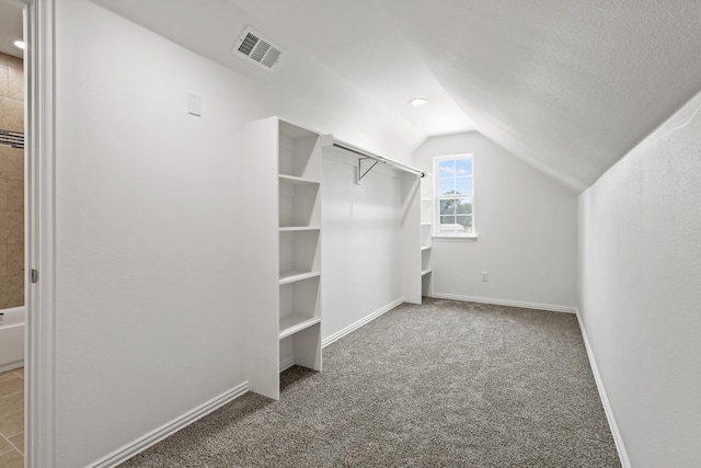 walk in closet featuring carpet and lofted ceiling