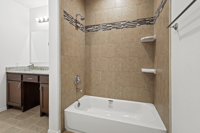 bathroom with tile patterned flooring, vanity, and tiled shower / bath