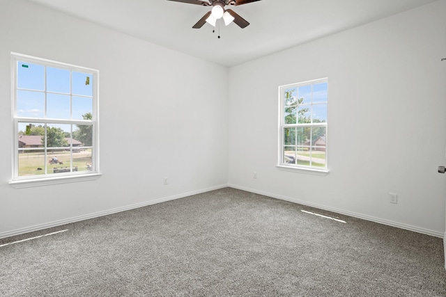 carpeted spare room featuring ceiling fan