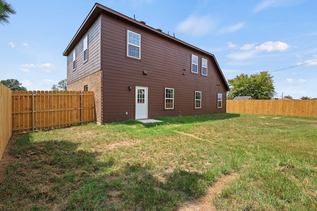 back of house featuring a lawn