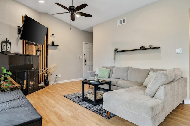 living room featuring ceiling fan, lofted ceiling, and wood-type flooring