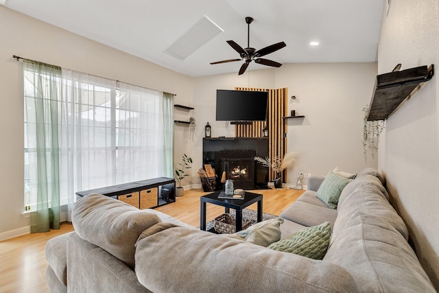 living room with ceiling fan, light hardwood / wood-style flooring, and lofted ceiling