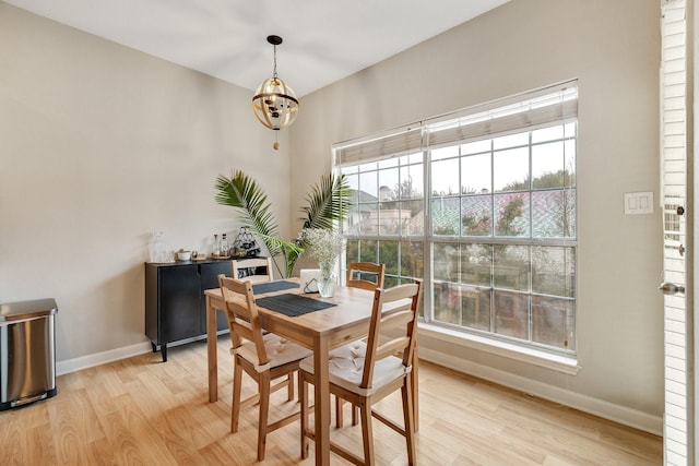 dining space featuring light hardwood / wood-style flooring and a notable chandelier