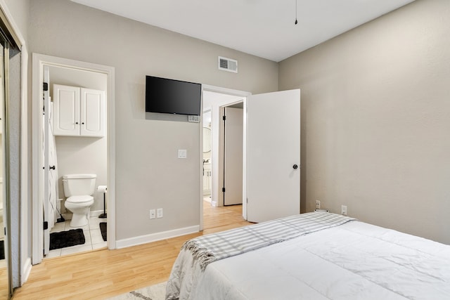 bedroom featuring light hardwood / wood-style flooring and ensuite bath