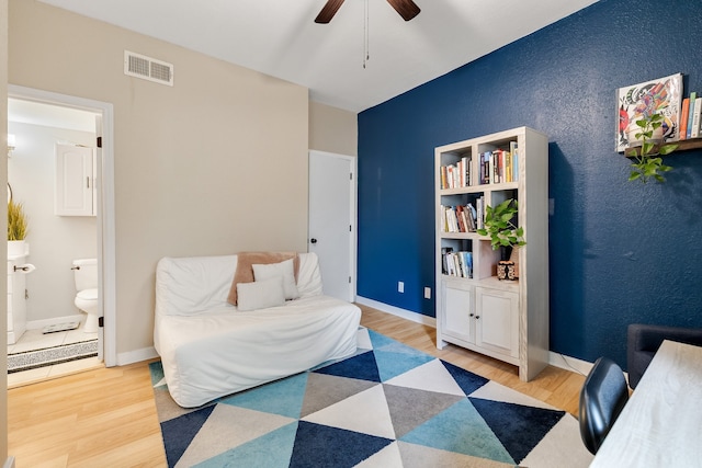 bedroom featuring ceiling fan, light hardwood / wood-style floors, and connected bathroom