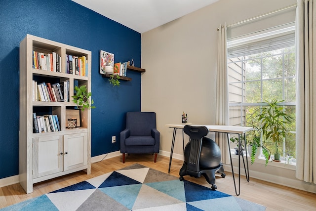 living area with light wood-type flooring and built in features