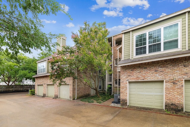 view of front of home with a garage and central air condition unit