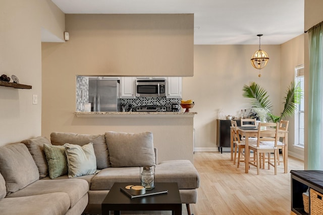 living room featuring light hardwood / wood-style floors and an inviting chandelier