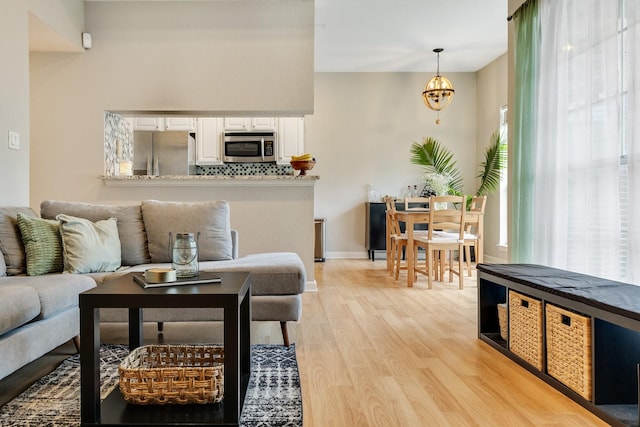 living room featuring a chandelier and light hardwood / wood-style flooring