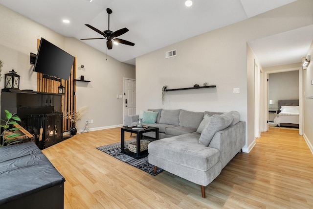 living room featuring ceiling fan, lofted ceiling, and hardwood / wood-style flooring