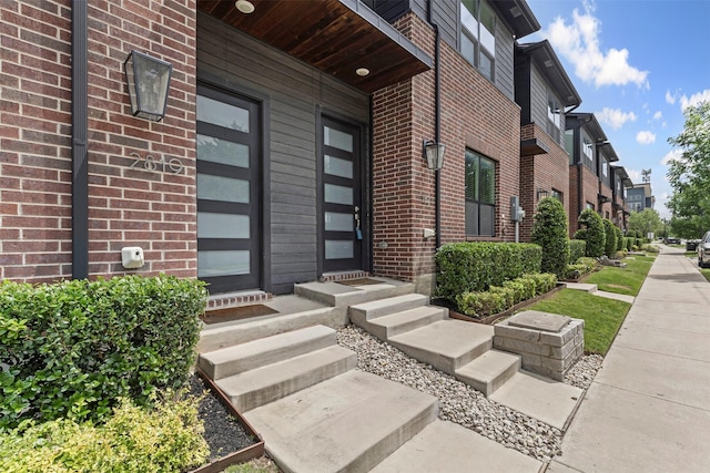 property entrance with brick siding and a residential view