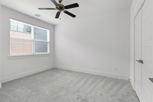 spare room featuring light colored carpet, baseboards, and visible vents