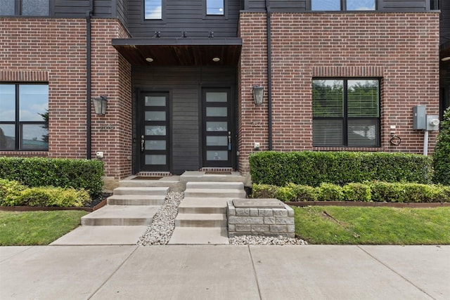 view of exterior entry featuring brick siding