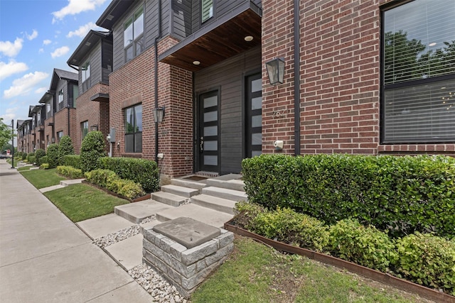 entrance to property featuring brick siding
