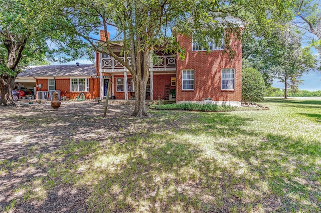 view of front of property with a front yard, brick siding, and a chimney