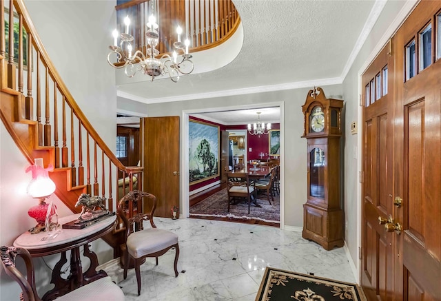 entrance foyer featuring stairway, marble finish floor, crown molding, a textured ceiling, and a notable chandelier