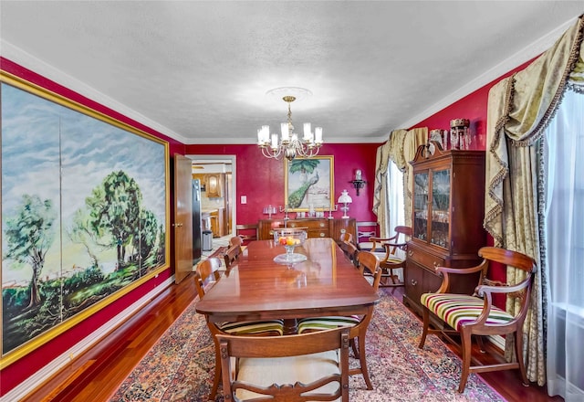 dining area with a textured ceiling, wood finished floors, and a notable chandelier