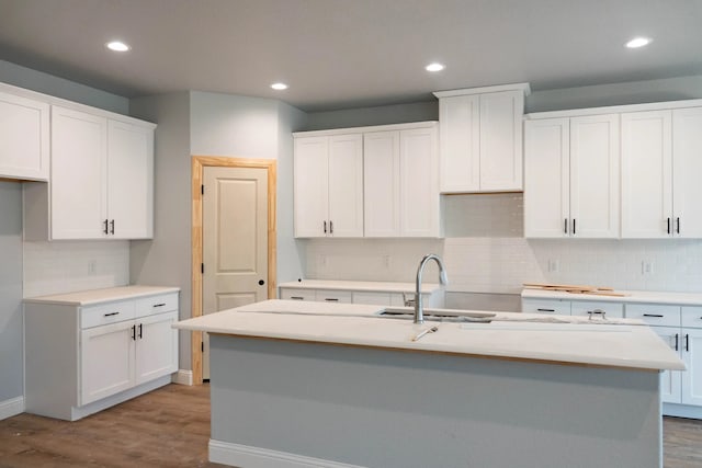 kitchen with an island with sink, white cabinetry, and light hardwood / wood-style floors