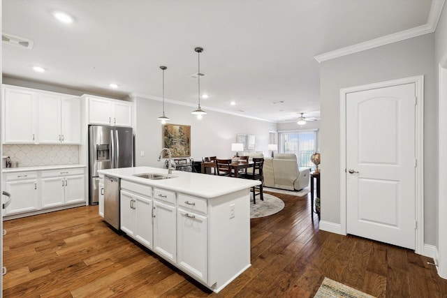 kitchen featuring decorative backsplash, wood finished floors, stainless steel appliances, crown molding, and a sink