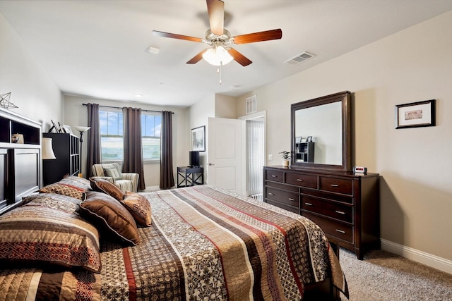 bedroom with light carpet, ceiling fan, visible vents, and baseboards