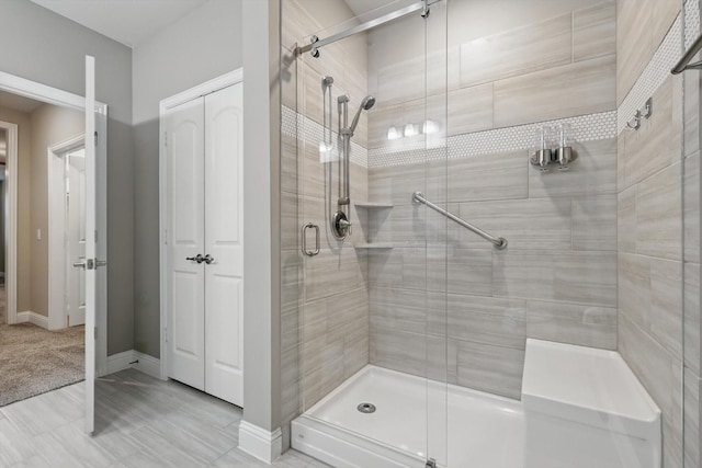 full bathroom featuring a shower stall and baseboards