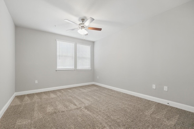 carpeted empty room featuring ceiling fan and baseboards