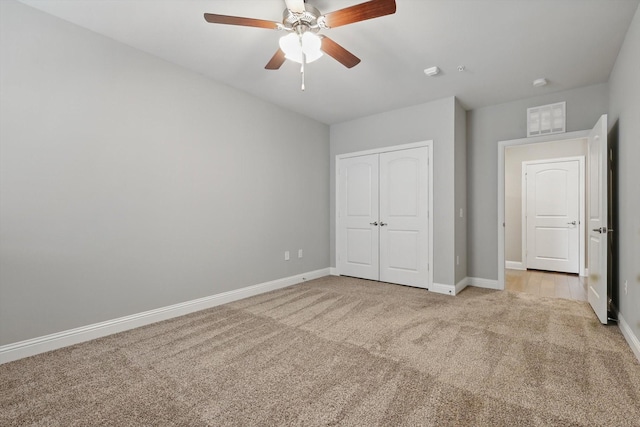 unfurnished bedroom with light carpet, baseboards, and a closet