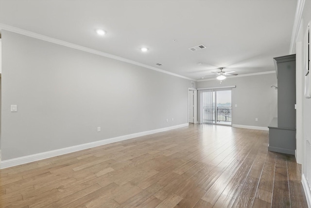 spare room featuring crown molding, light wood finished floors, visible vents, a ceiling fan, and baseboards