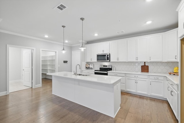 kitchen with light wood-style flooring, a sink, visible vents, appliances with stainless steel finishes, and an island with sink