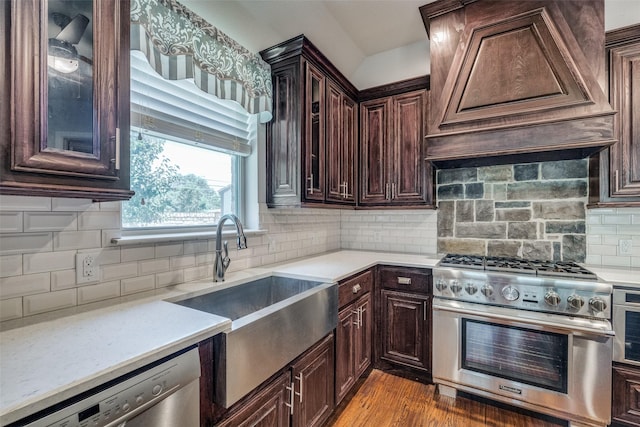 kitchen with dark brown cabinetry, sink, stainless steel appliances, and custom range hood