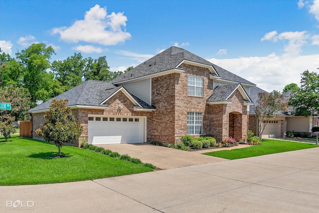 view of property featuring a garage and a front lawn