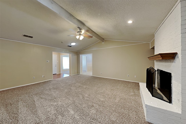 unfurnished living room featuring a textured ceiling, carpet, a fireplace, vaulted ceiling with beams, and ceiling fan