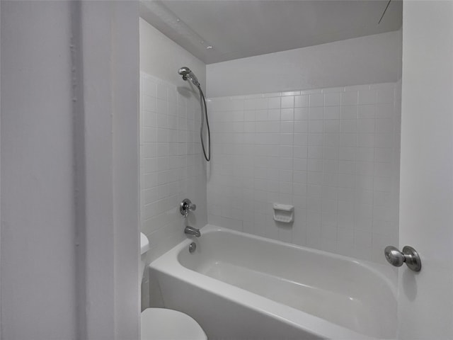 bathroom with toilet and tiled shower / bath