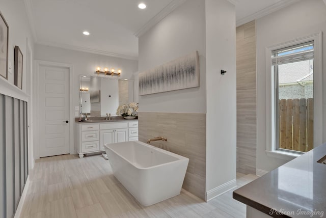 bathroom featuring vanity, tile walls, ornamental molding, and a washtub