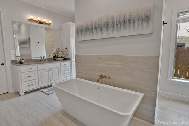 bathroom featuring vanity, tile walls, ornamental molding, and a washtub