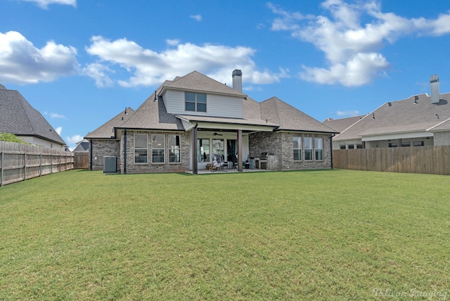 back of house with central air condition unit, a patio area, and a lawn