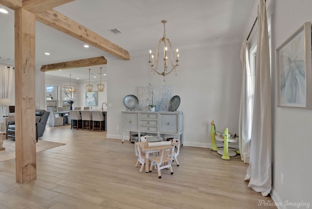 dining space featuring light hardwood / wood-style floors, an inviting chandelier, and beamed ceiling