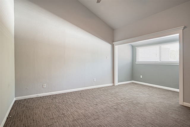 carpeted spare room with lofted ceiling