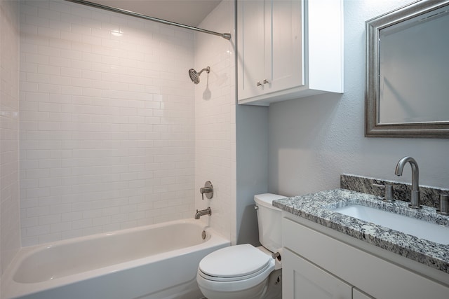 full bathroom featuring tiled shower / bath combo, vanity, and toilet