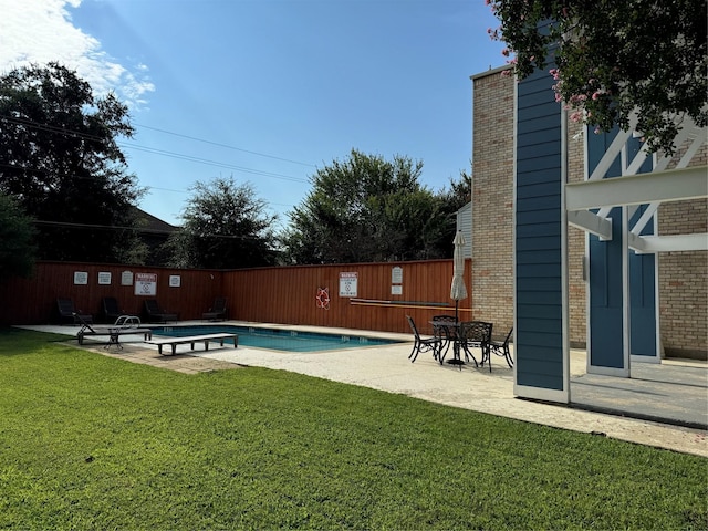 view of swimming pool featuring a patio and a yard