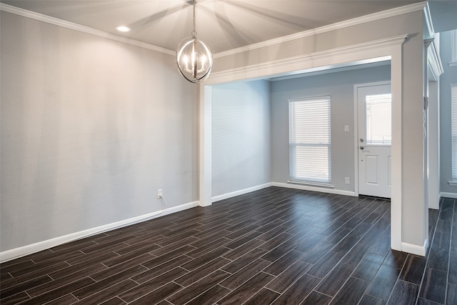 spare room featuring an inviting chandelier, ornamental molding, and dark hardwood / wood-style flooring