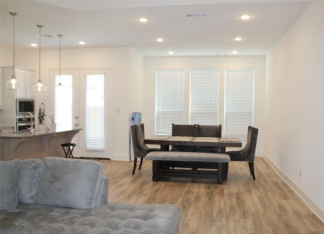 dining area with french doors and light hardwood / wood-style floors