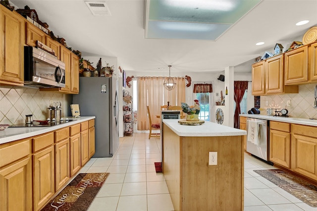 kitchen featuring appliances with stainless steel finishes, visible vents, a kitchen island, and light tile patterned floors