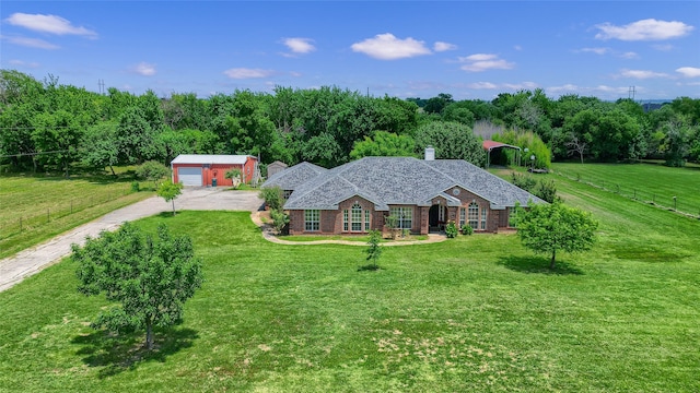 view of front of property with a front yard, driveway, an outdoor structure, and fence