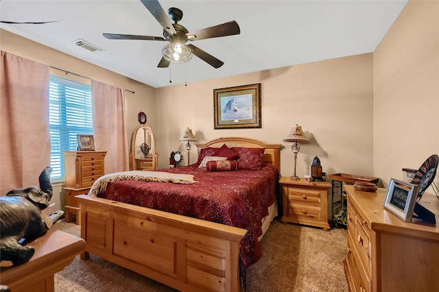 carpeted bedroom with ceiling fan and visible vents