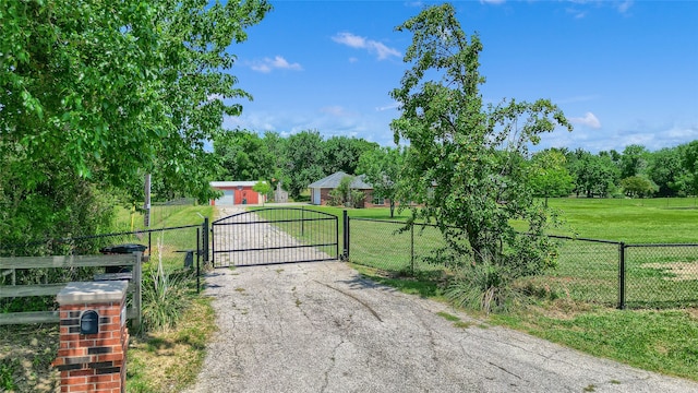 view of gate with fence and a yard