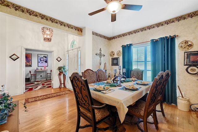 dining space featuring ceiling fan with notable chandelier and hardwood / wood-style floors